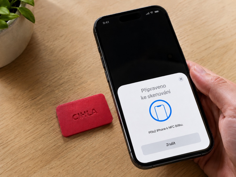 iPhone připravený ke skenování NFC, vedle něj cihla